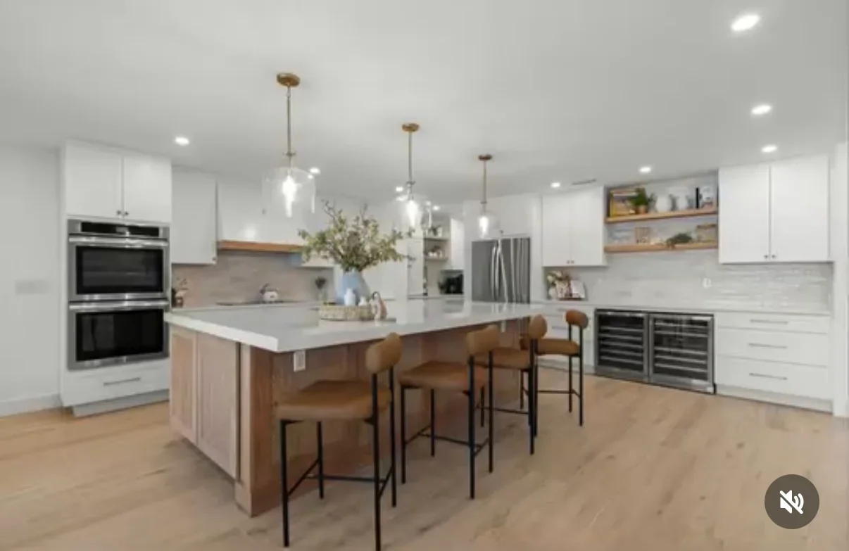 White cabinetry kitchen with wood island, quartz counters, stainless steel appliances, and pendant lights