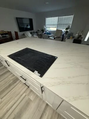 White quartz kitchen island with waterfall edge and white painted cabinetry