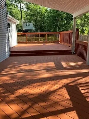 Composite deck with diagonal board pattern, railings, and covered patio overhead