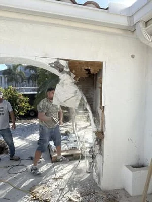 Enlarged doorway opening with removed wall section and exposed framing during renovation