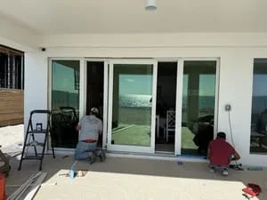 Multi-panel white sliding glass doors installed in residential interior with drywall framing