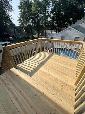 Newly constructed pressure-treated wood deck with spindle railings and composite decking