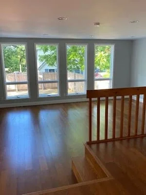 Four-panel glass patio doors with wood trim in open living room with hardwood floors